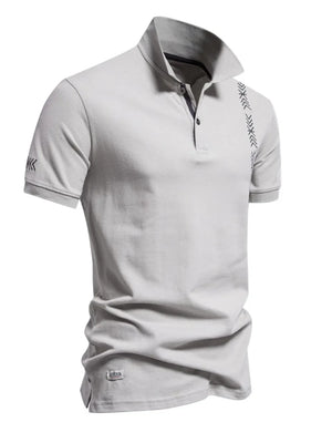 Gray piqué polo shirt with chevron embroidery on chest and sleeve, short sleeves, and button neck.