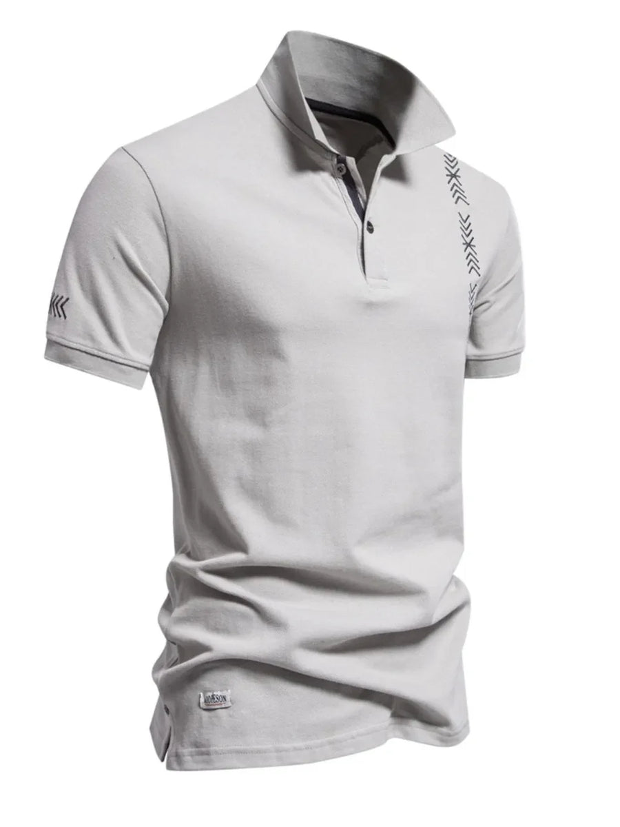Gray piqué polo shirt with chevron embroidery on chest and sleeve, short sleeves, and button neck.