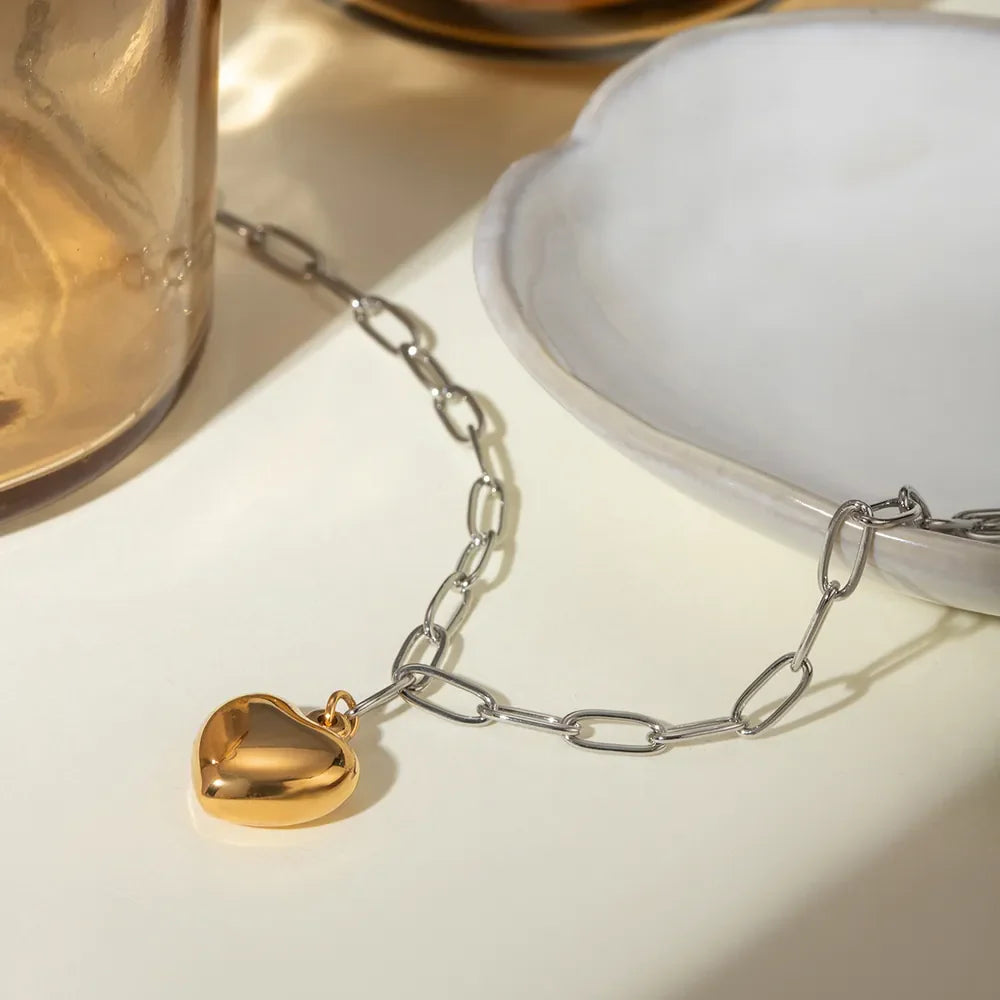 Two-tone heart chain necklace with a gold heart charm and silver chain.