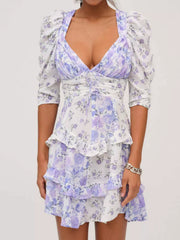 Ruched floral tie-front dress with puff sleeves and tiered ruffles in purple and white.