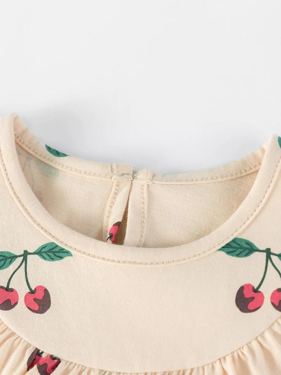 Baby dress with cherry print, ruffle neck, and pull-over closure.
