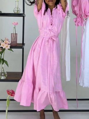 Pink linen midi dress with ruffle neckline, tie waist, and tiered skirt.