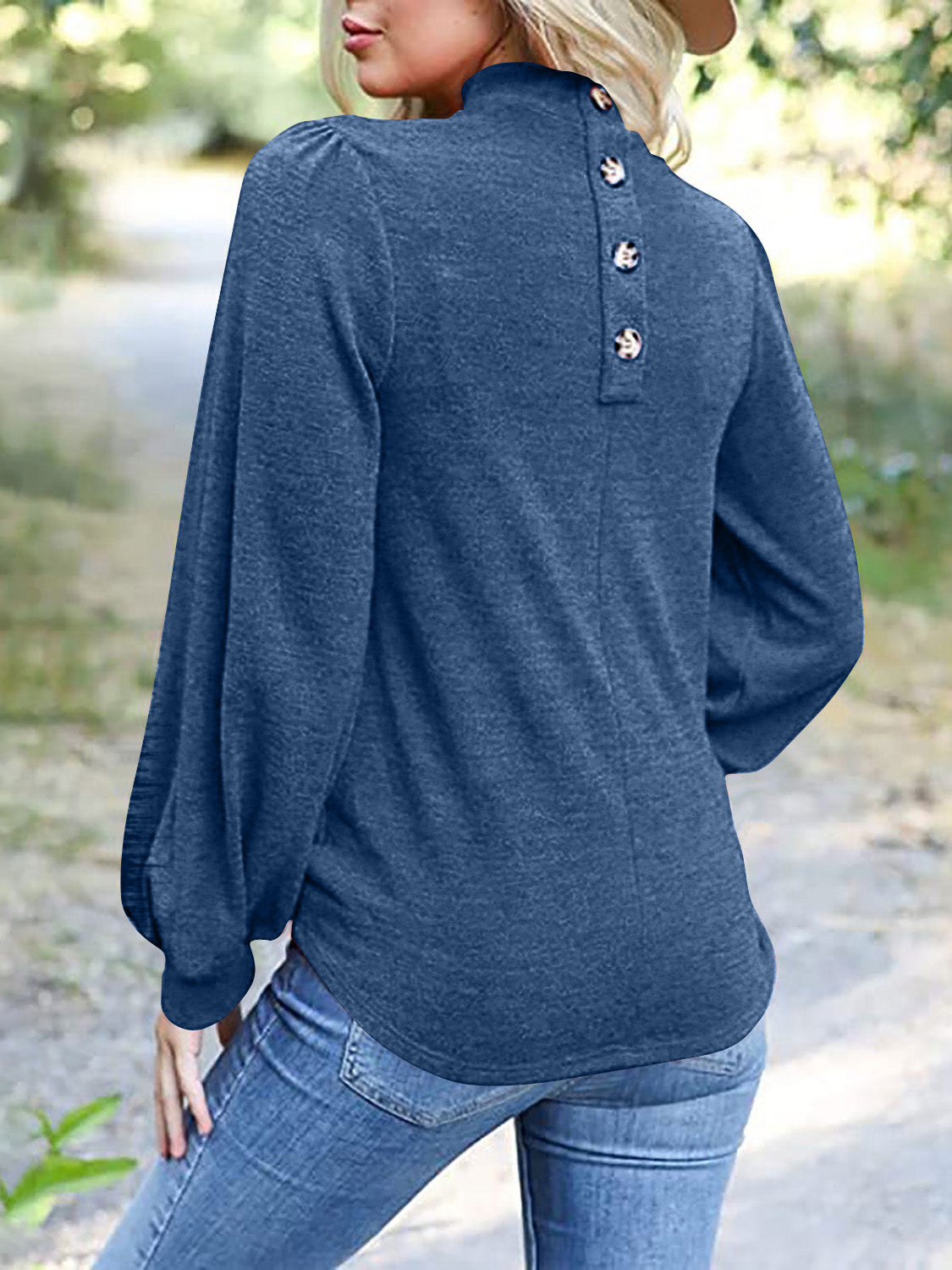 Dusty blue mock neck top with puff sleeves and button-back detail.