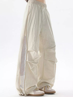 Cream cargo sweatpants with adjustable waist and mesh side detail.