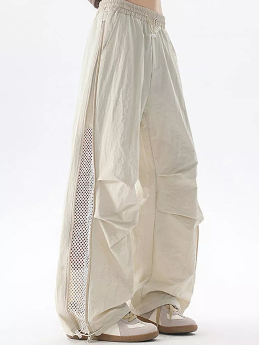 Cream cargo sweatpants with adjustable waist and mesh side detail.