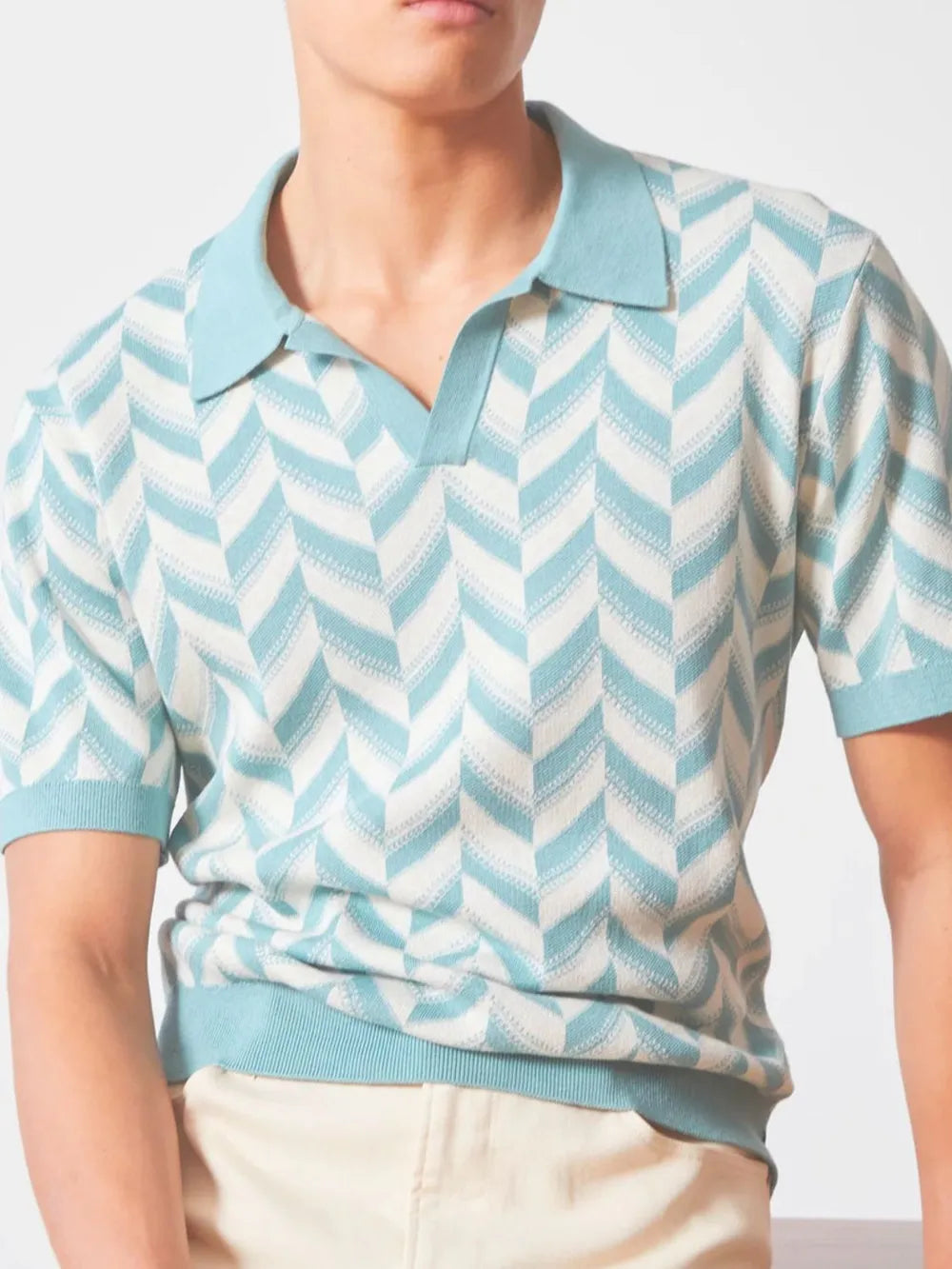 Chevron knit polo shirt in pastel blue with a V-neck collar and short sleeves.