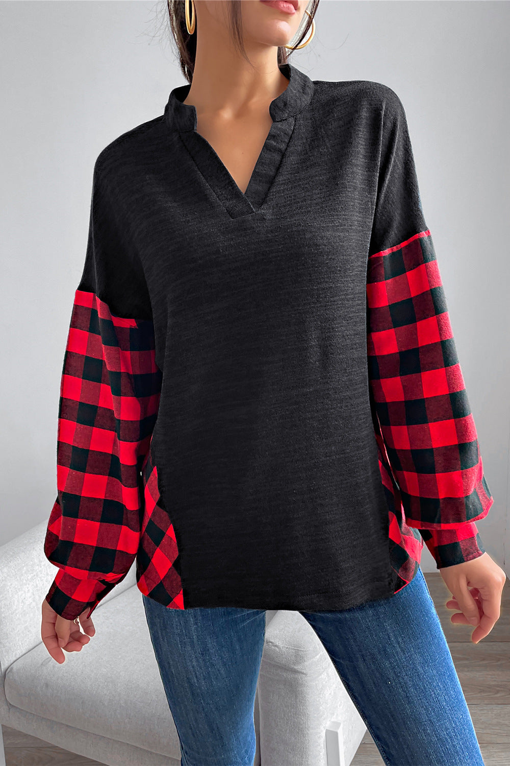 Black henley top with contrast red buffalo plaid balloon sleeves and hem accents.