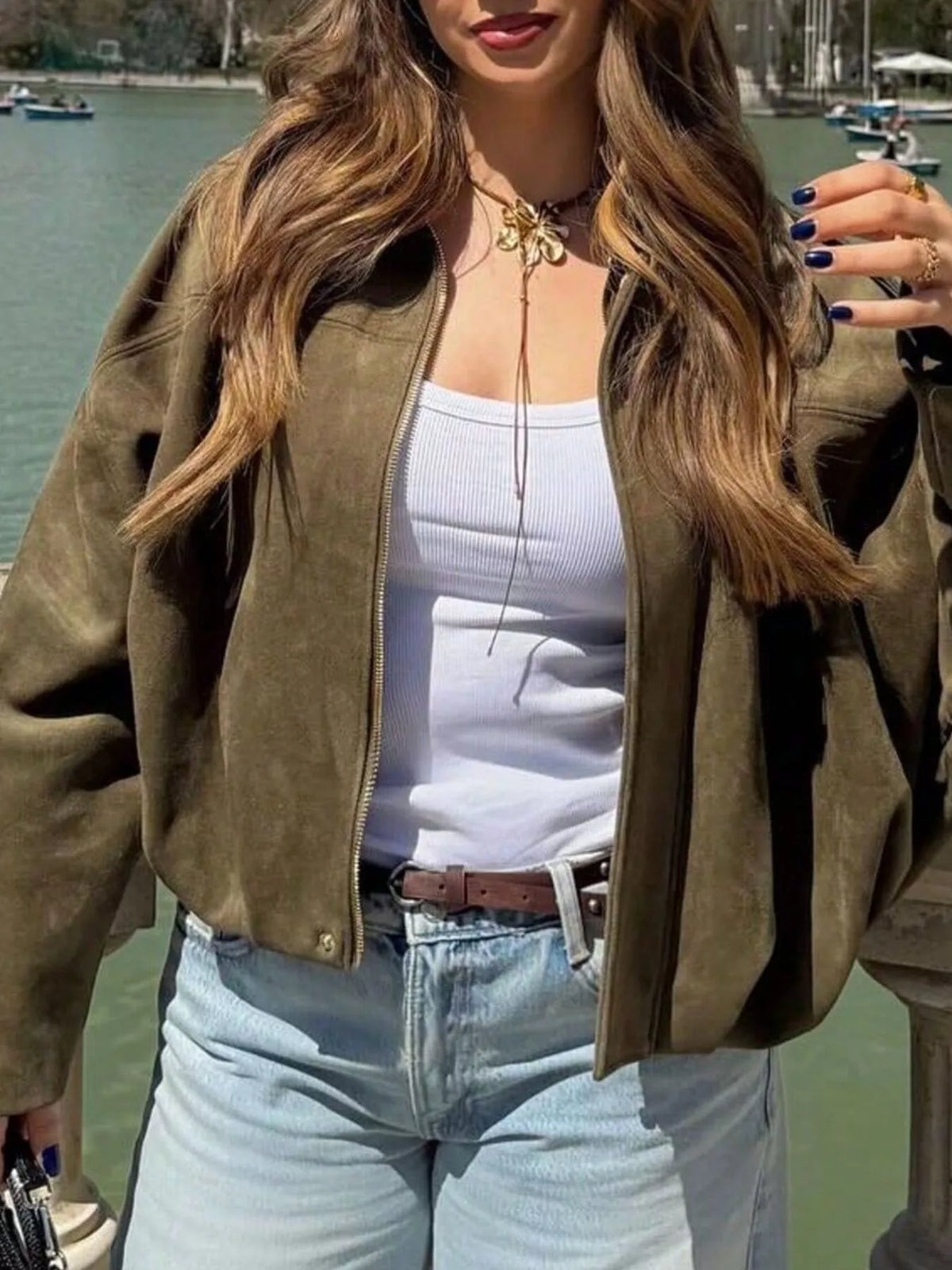 Oversized military green zip-up jacket with a ribbed hem and cuffs, styled with a white tank top.