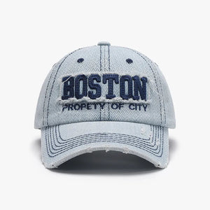 Distressed light wash denim baseball cap with embroidered Boston text and frayed details.