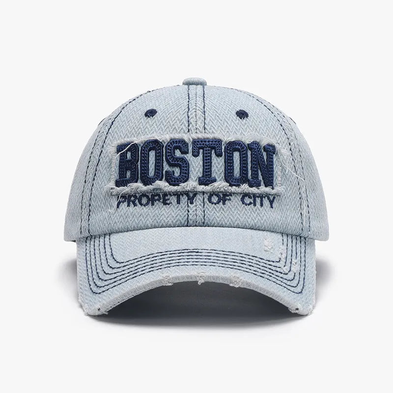 Distressed light wash denim baseball cap with embroidered Boston text and frayed details.