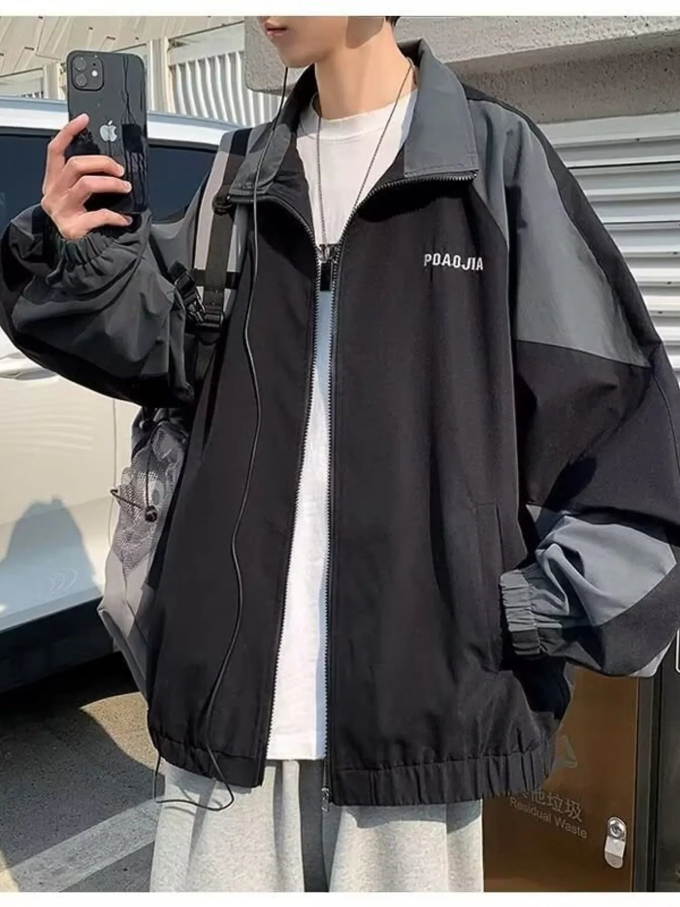 Plus-size two-tone black and grey windbreaker jacket with zip front and elastic cuffs.