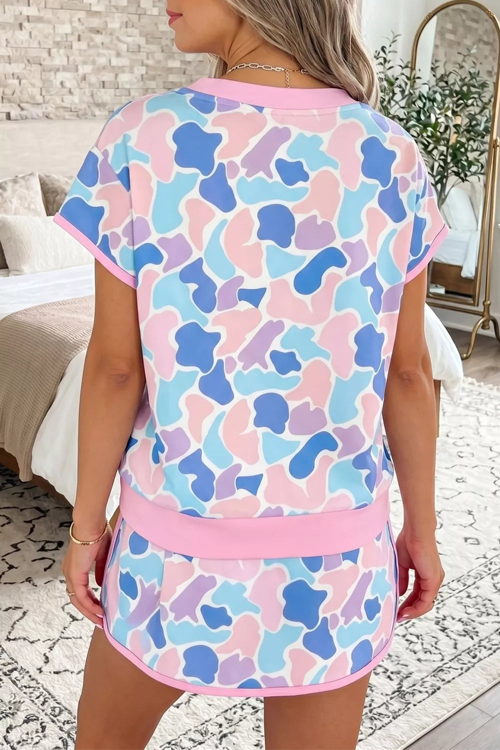 Pastel camouflage athletic two-piece set with crew neck top and shorts.