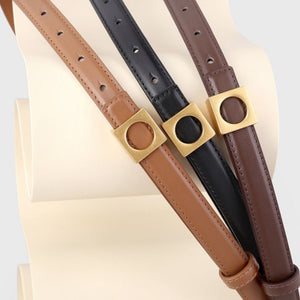Skinny cowhide leather belts in brown, black, and olive brown with gold square buckles.