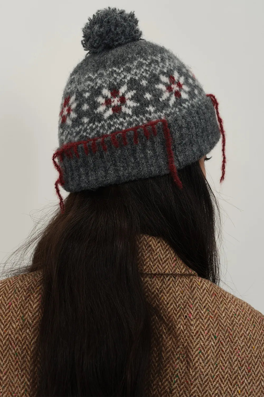 Dark gray Fair Isle beanie with pom-pom and red tassel detail