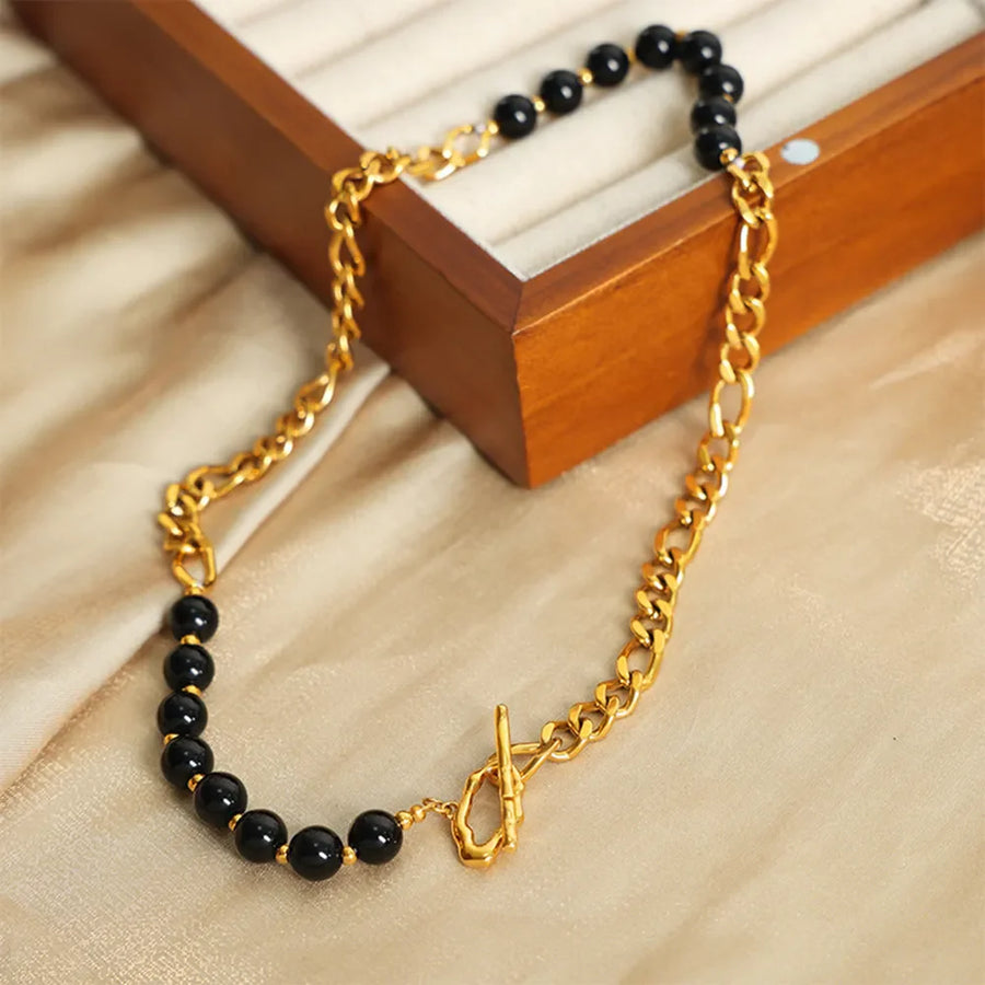 Gold asymmetrical necklace with black beads and chain detail