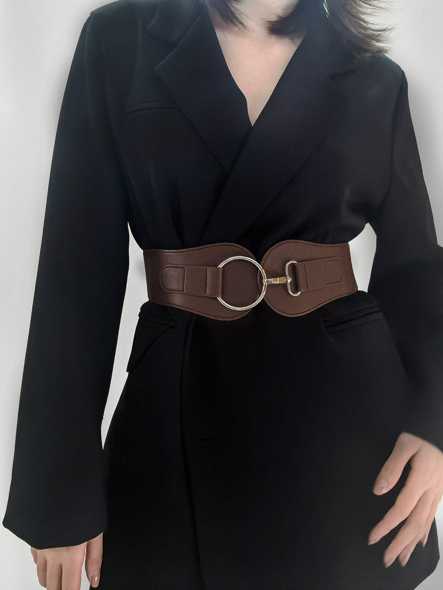 Brown cincher belt with silver ring buckle detail worn over a black blazer
