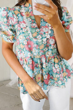 Floral peplum blouse with scallop trim and puff sleeves.