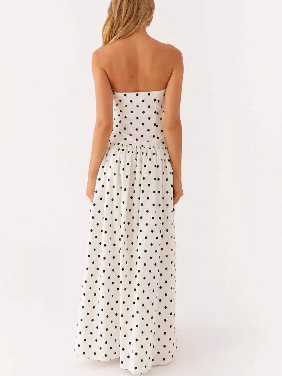 White polka dot strapless maxi dress with a tiered skirt.