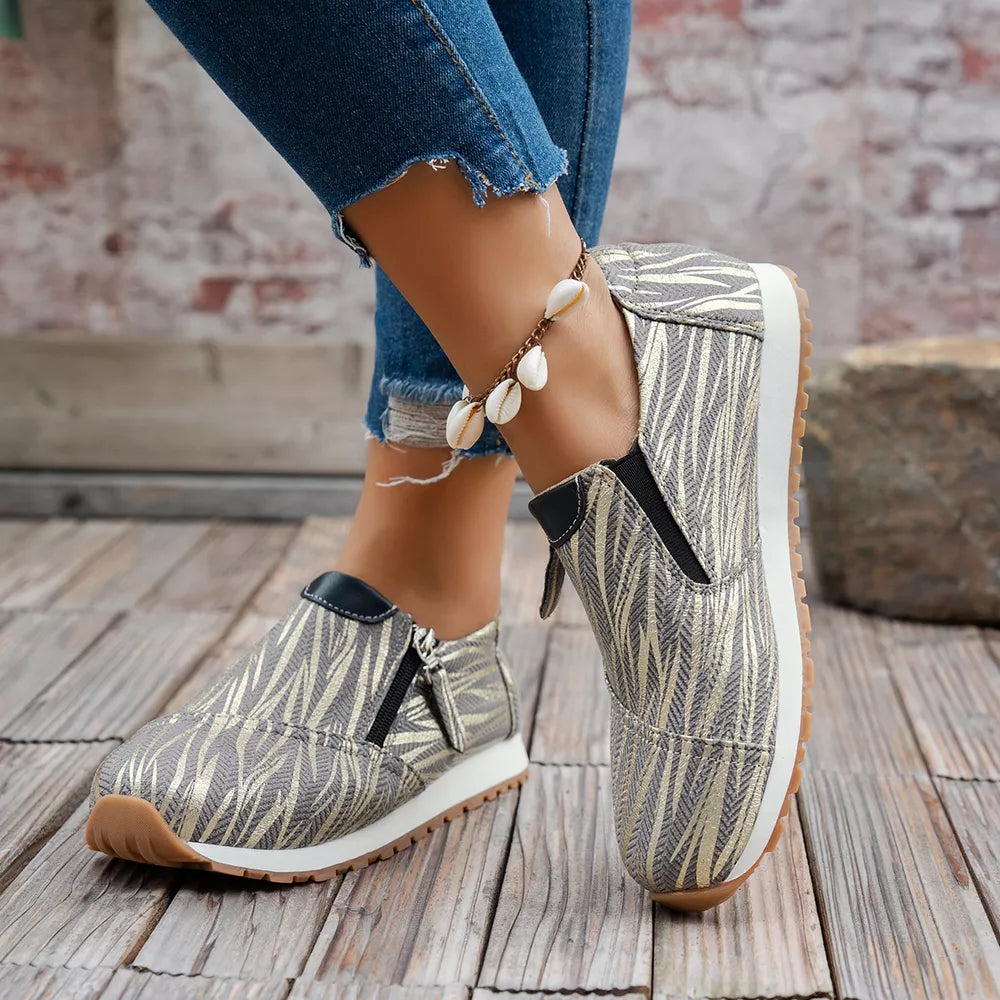 Zebra print slip-on flats in grey with side zippers and a comfortable sole.