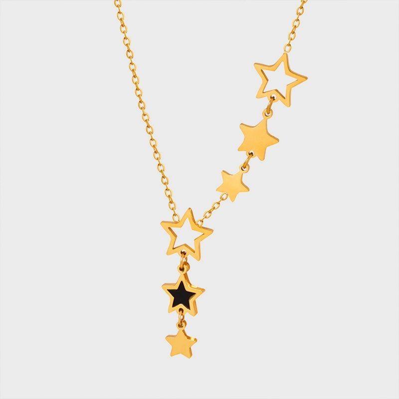 Gold celestial necklace with cascading star charms, one black star accent.