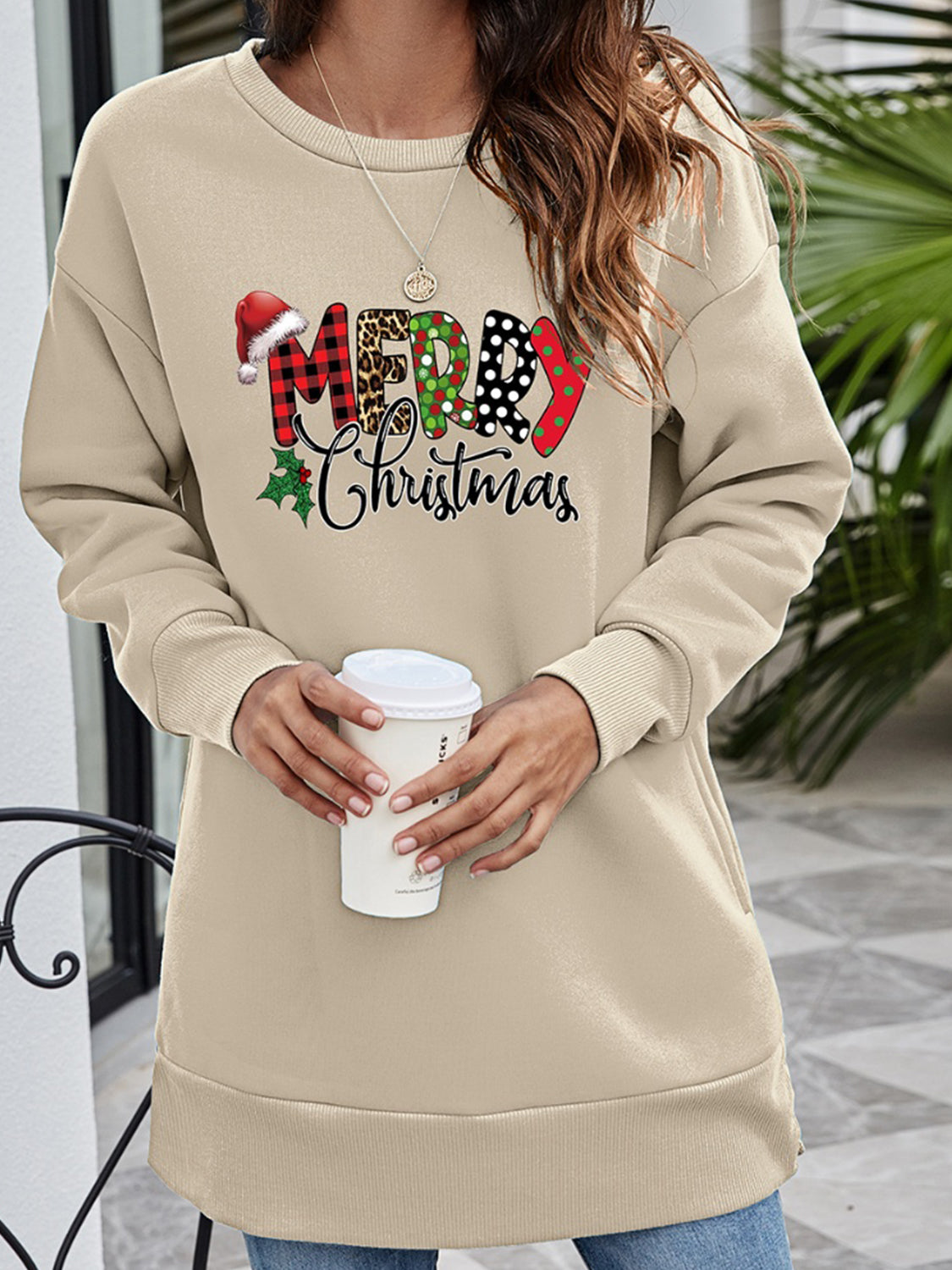 Beige crewneck sweatshirt with festive "Merry Christmas" graphic and holly detail.