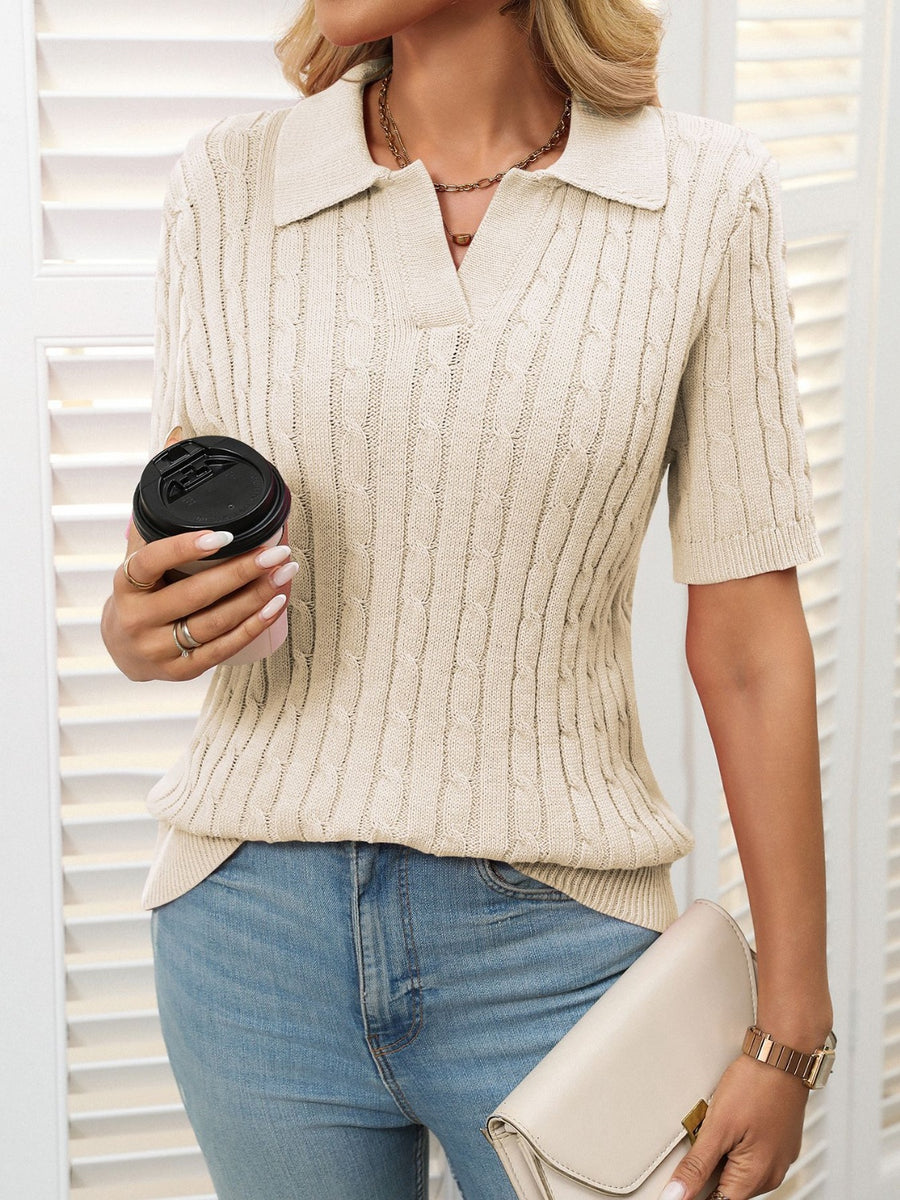 Beige cable knit polo sweater with short sleeves and a collar.