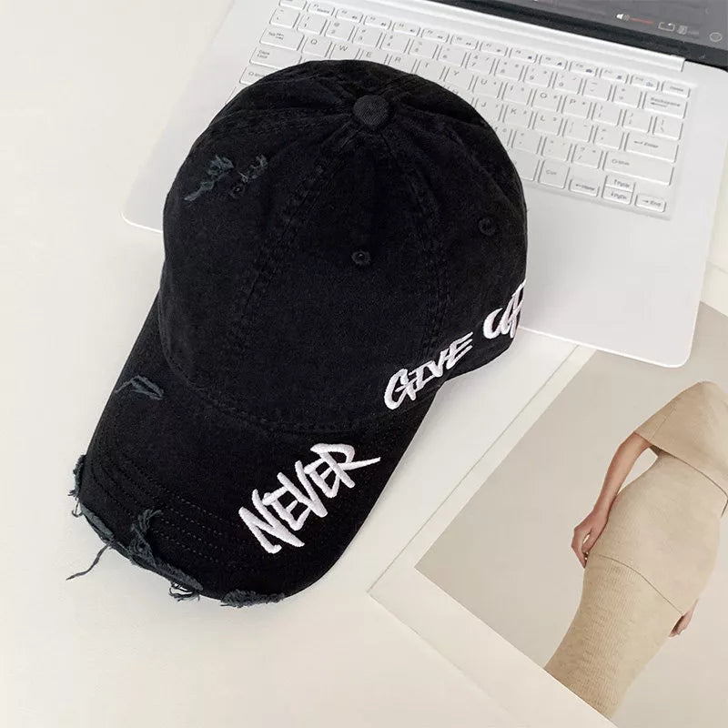 Black distressed cotton baseball cap with white embroidered text "NEVER GIVE UP