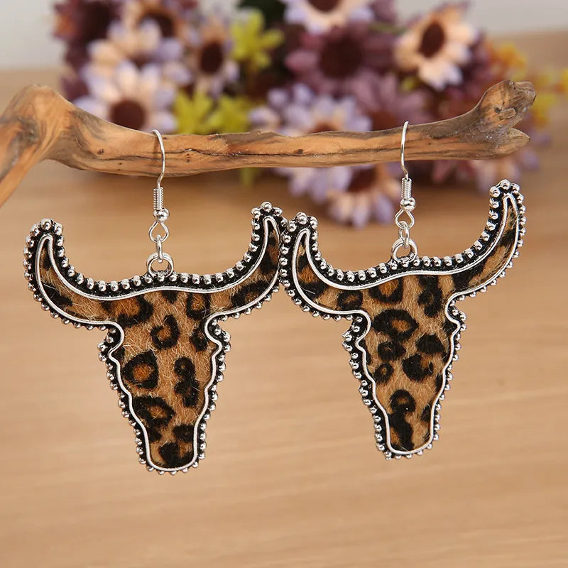 Leopard print bull head drop earrings with silver trim.