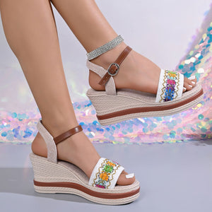 Embroidered floral wedge sandals with adjustable strap and espadrille sole.