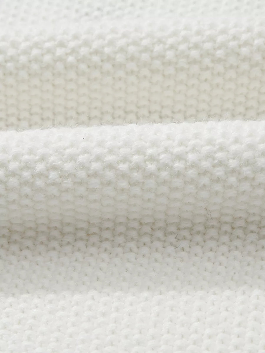 White chenille chunky knit sweater with crew neck, showing fabric texture.