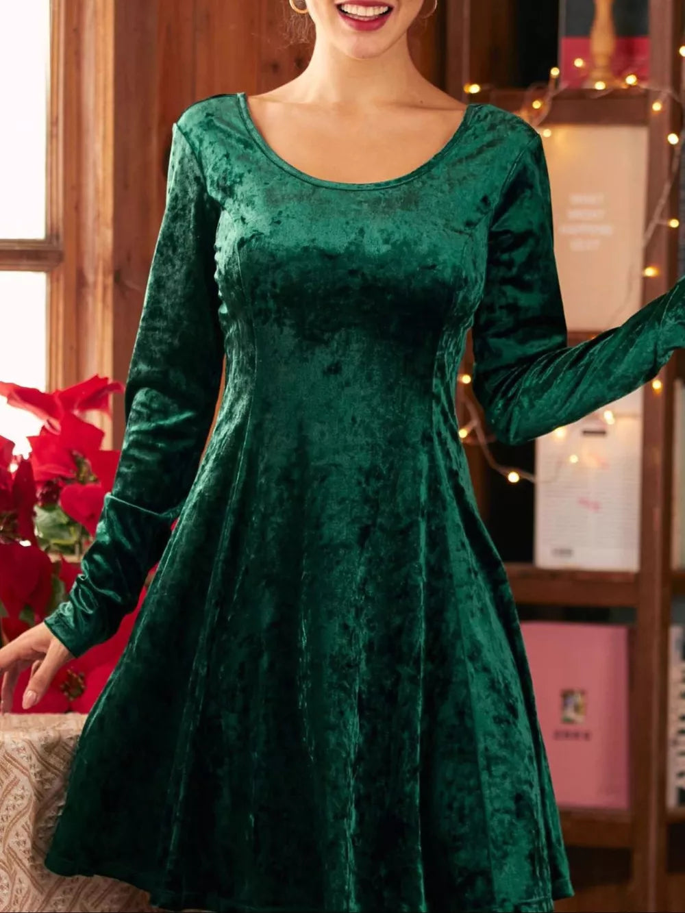 Green velvet a-line gown with round neck and long sleeves.