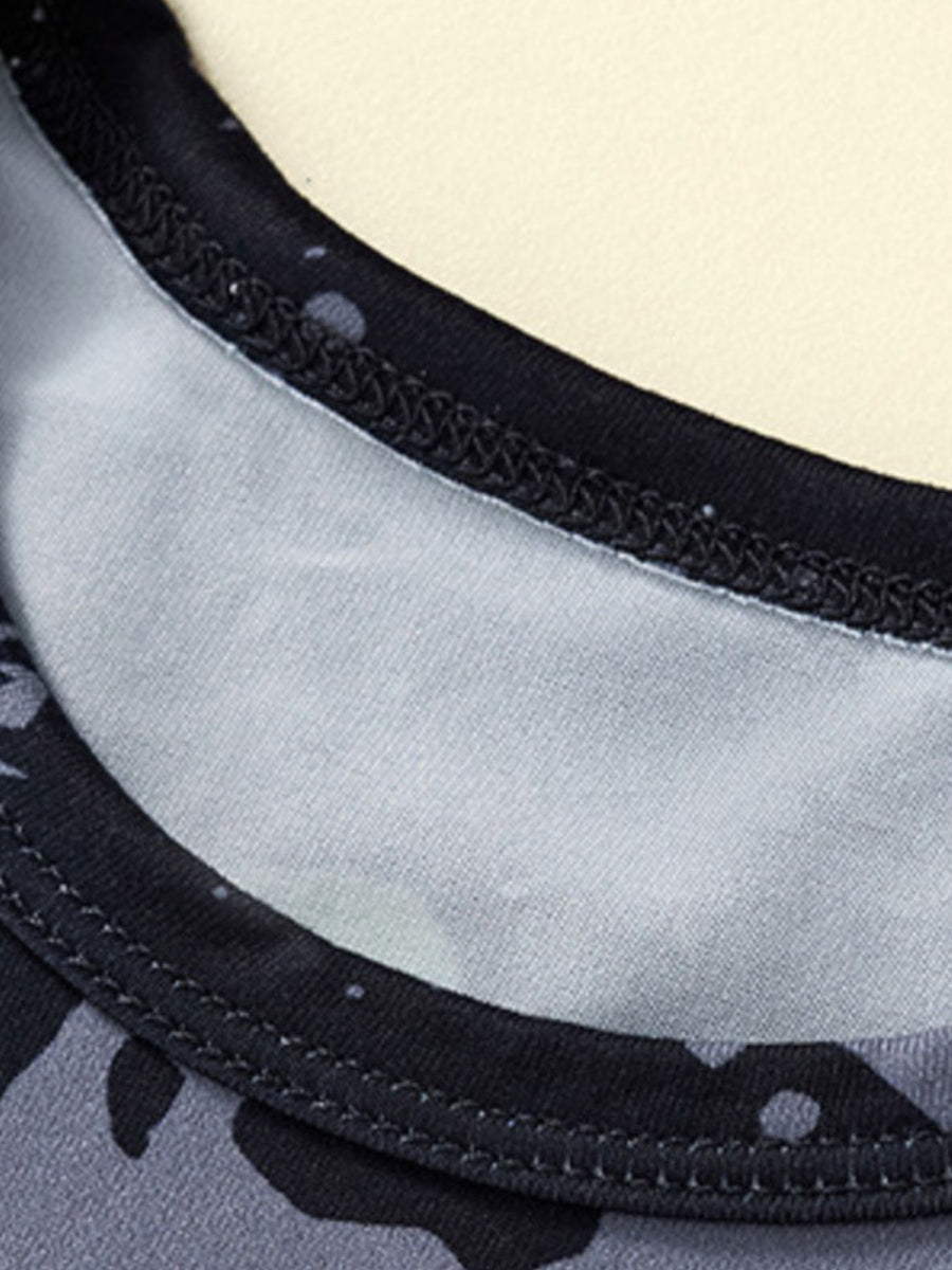 Dinosaur print toddler pajama set neckline detail with black trim and grey camouflage pattern.