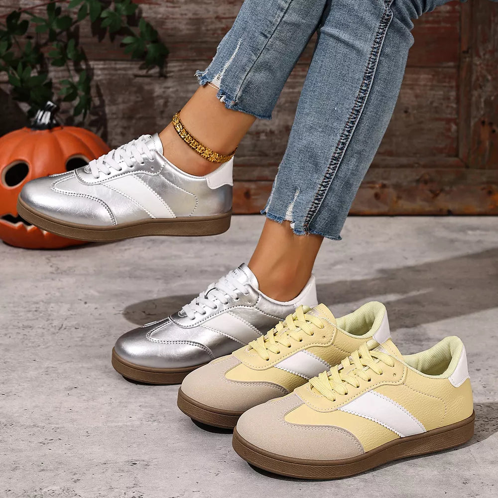 Metallic patent leather lace-up sneakers in silver and yellow with white accents.