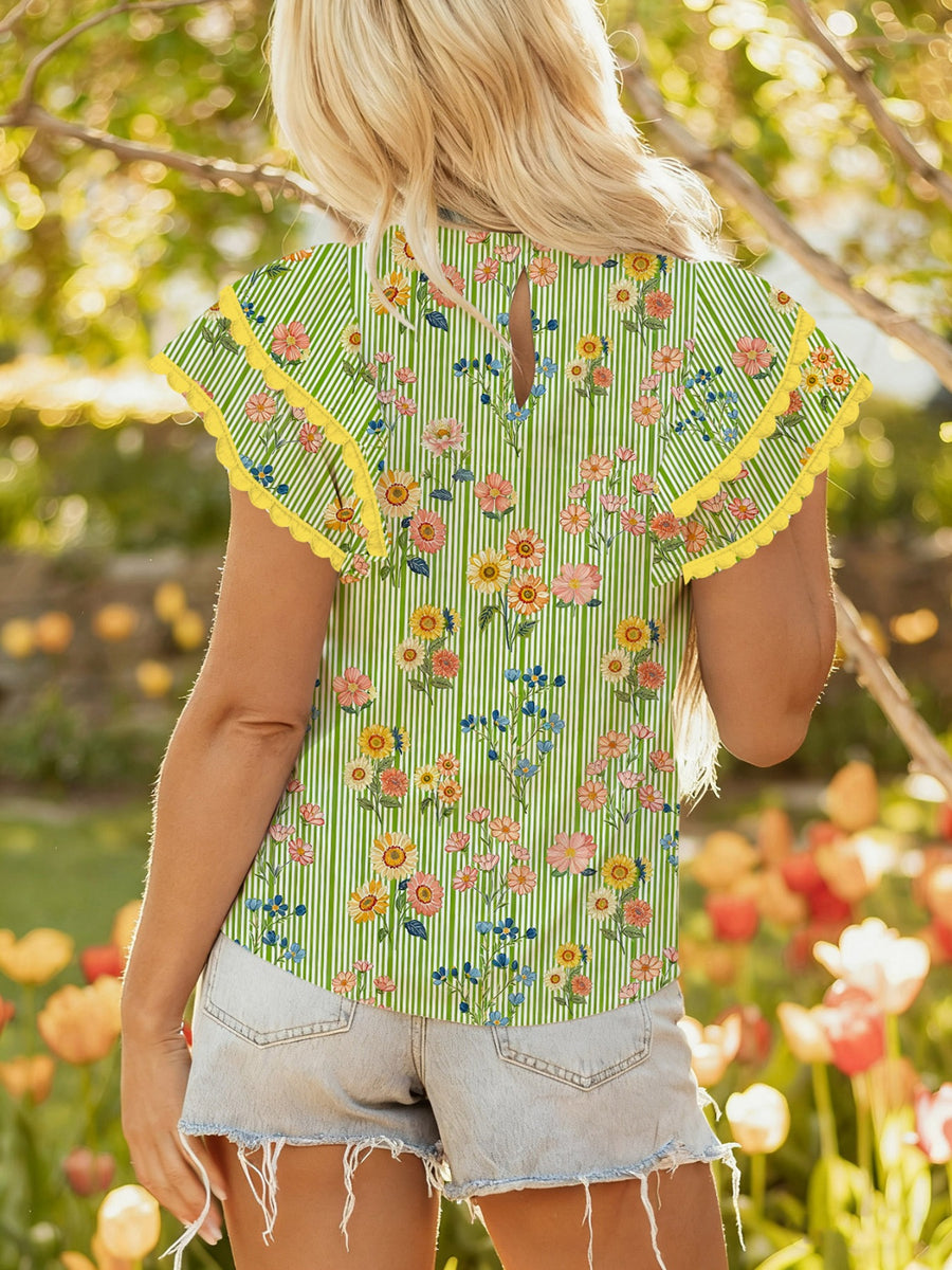 Floral printed cotton blouse with ruffle sleeves and yellow trim.
