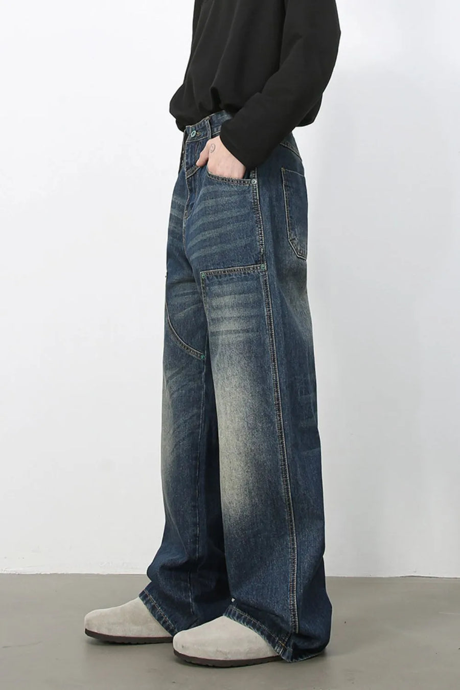 Medium wash distressed wide-leg jeans with a relaxed fit and visible stitching details.