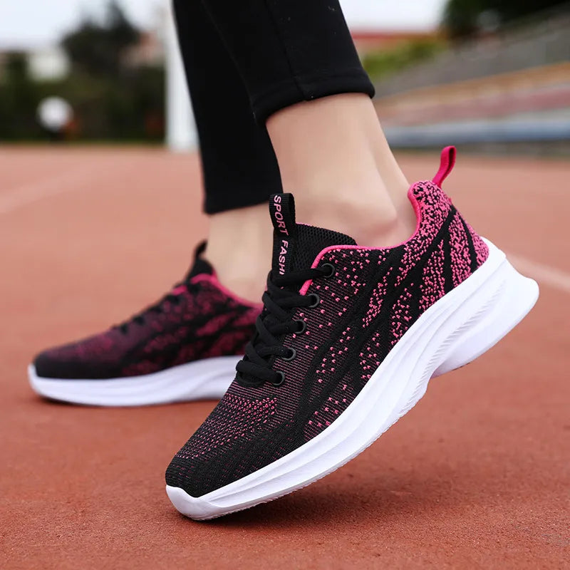 Textured knit athletic shoes in black with pink accents and white soles.