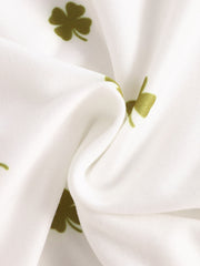 Baby bodysuit with clover print in clover green on white fabric.