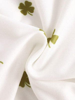 Baby bodysuit with clover print in clover green on white fabric.