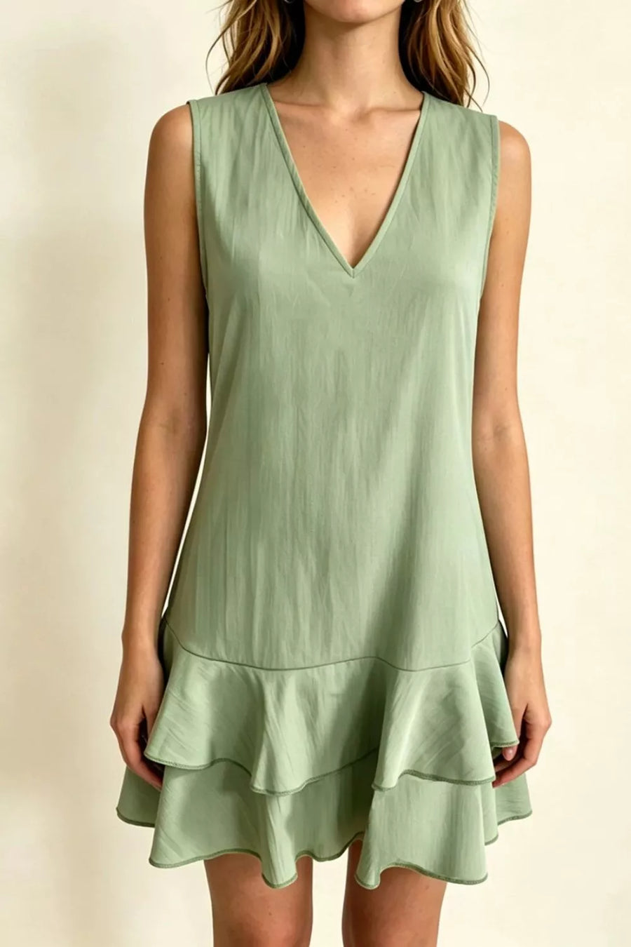 Sage green V-neck mini dress with tiered ruffle hem and sleeveless design.