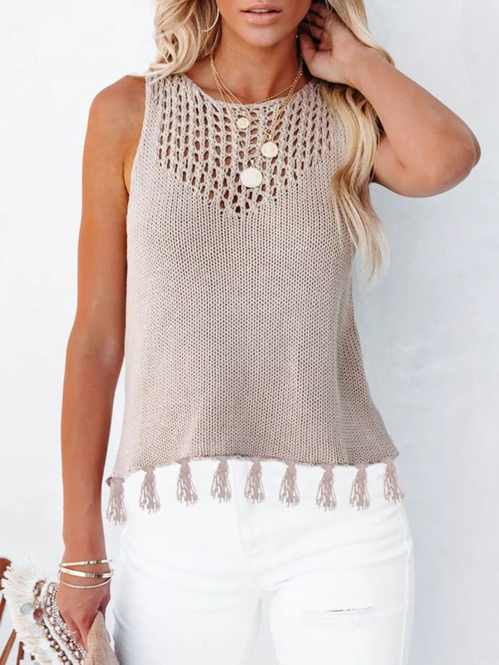 Knit tank top with crochet neckline and tassel hem in beige.