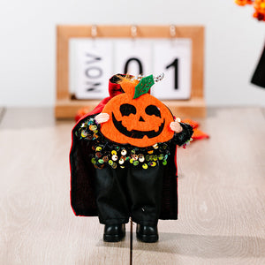 Halloween doll with pumpkin head, black cape, and sequin collar.