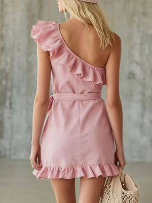 Blush pink one-shoulder ruffle trim wrap dress with tie waist and ruffled hem.