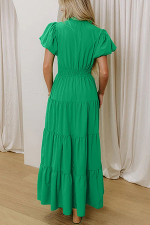 Green maxi dress with puff sleeves, smocked waist, and tiered skirt.