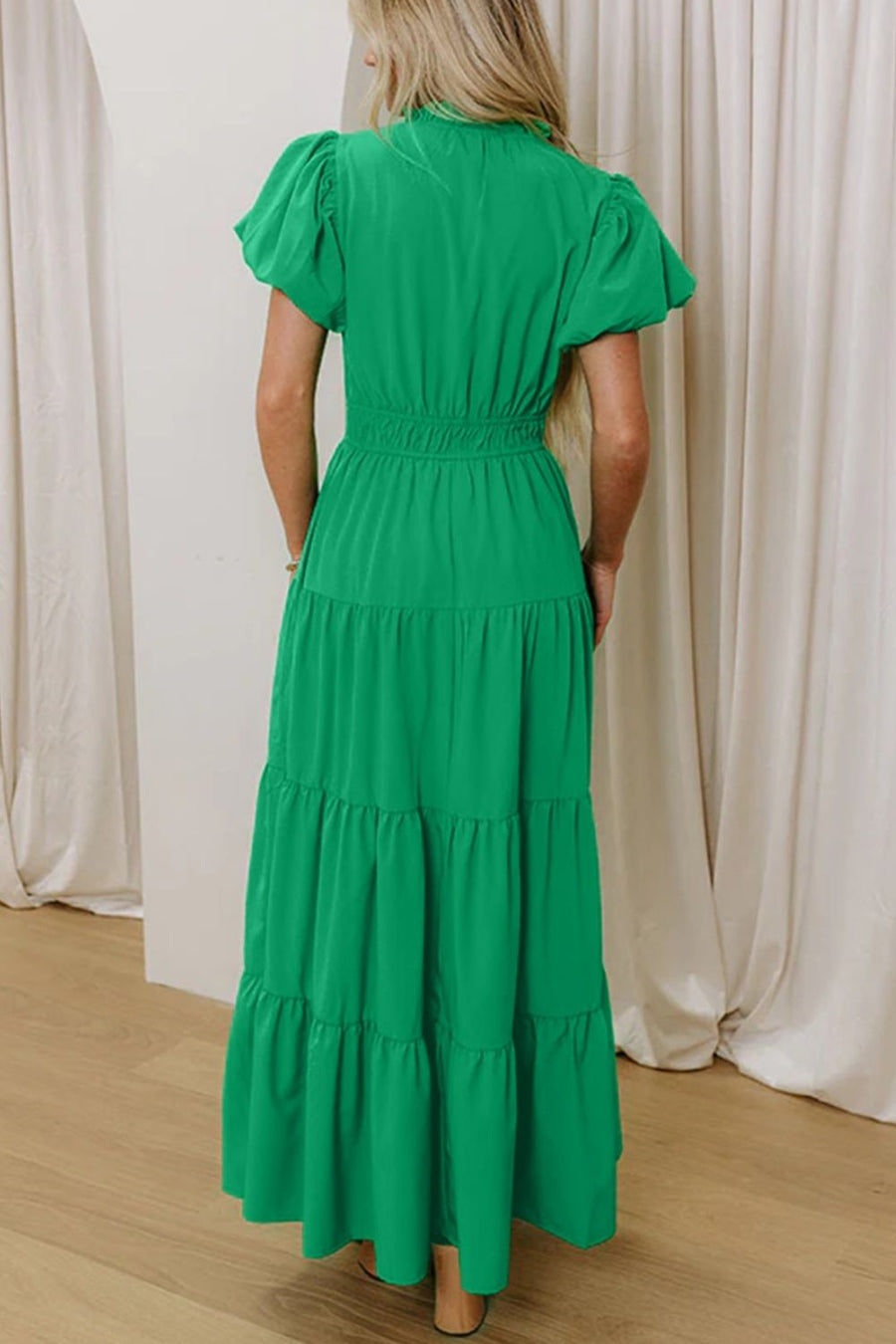 Green maxi dress with puff sleeves, smocked waist, and tiered skirt.