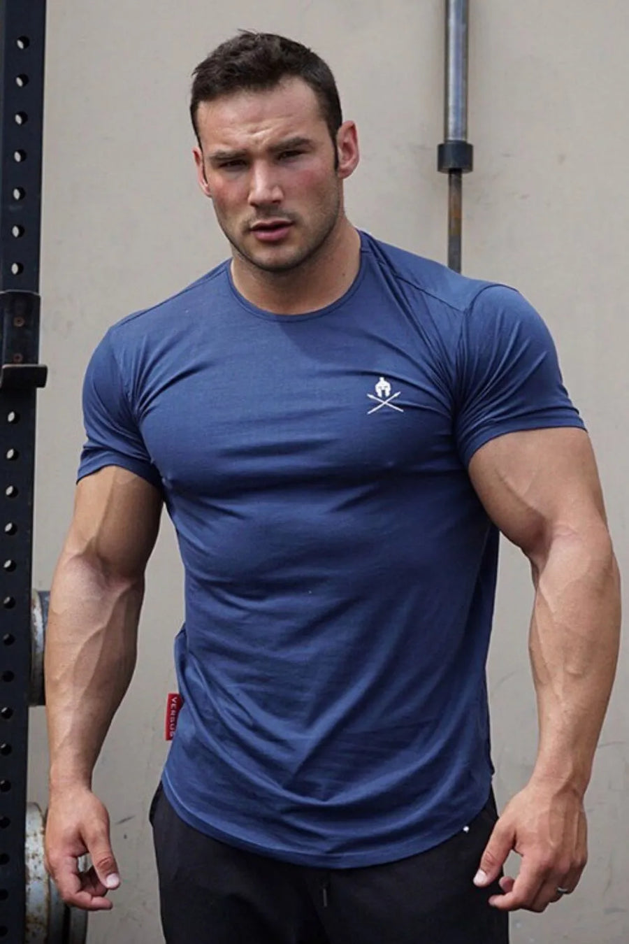 Dusty Blue activewear t-shirt with white logo detail on chest and red tag on side.