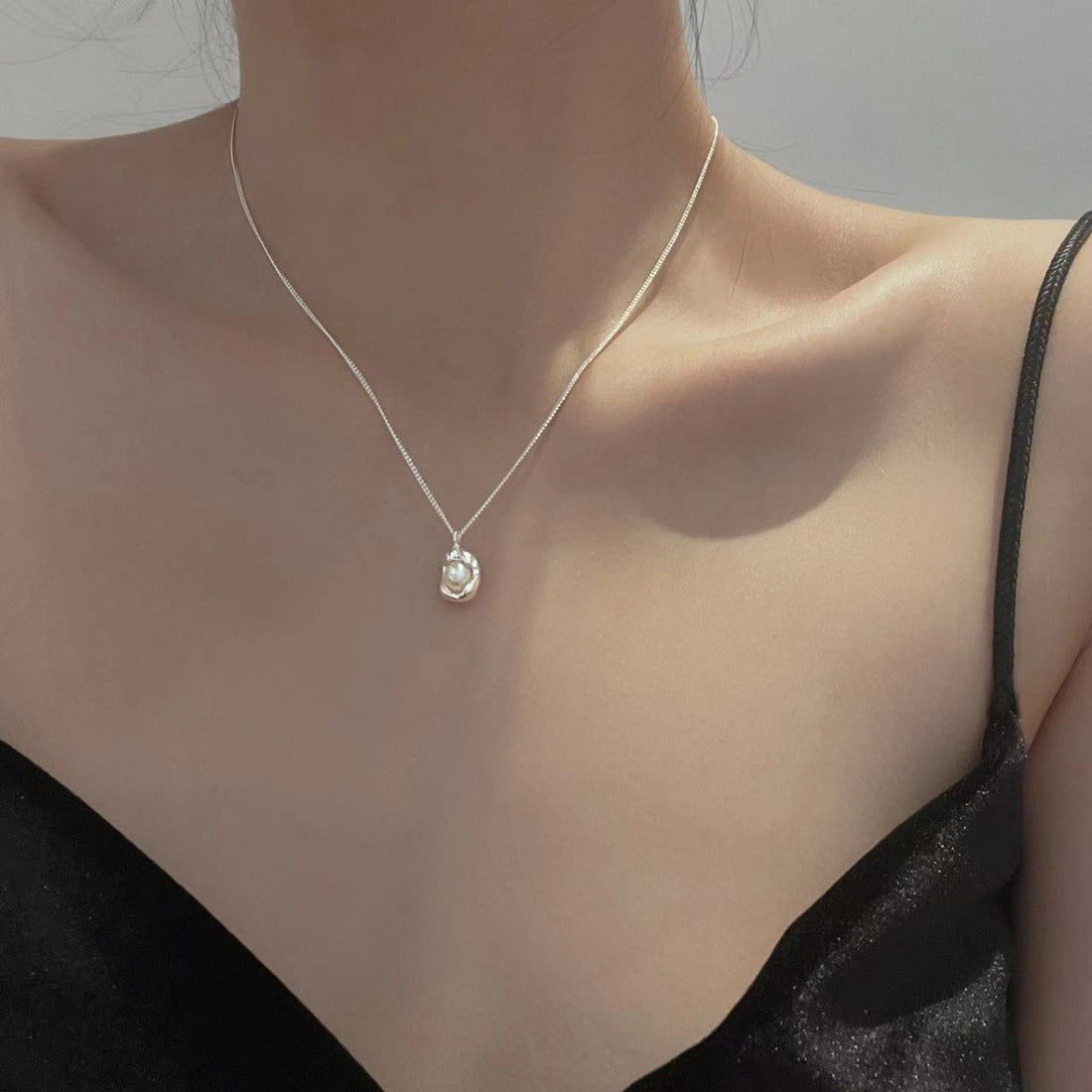 Sterling silver pendant necklace with a single pearl, delicate chain.