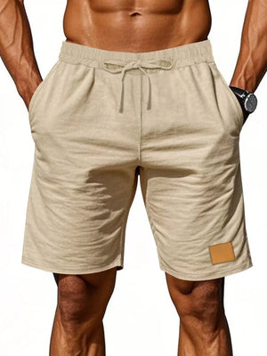 Light Khaki chino shorts with drawstring waist and faux leather patch detail.