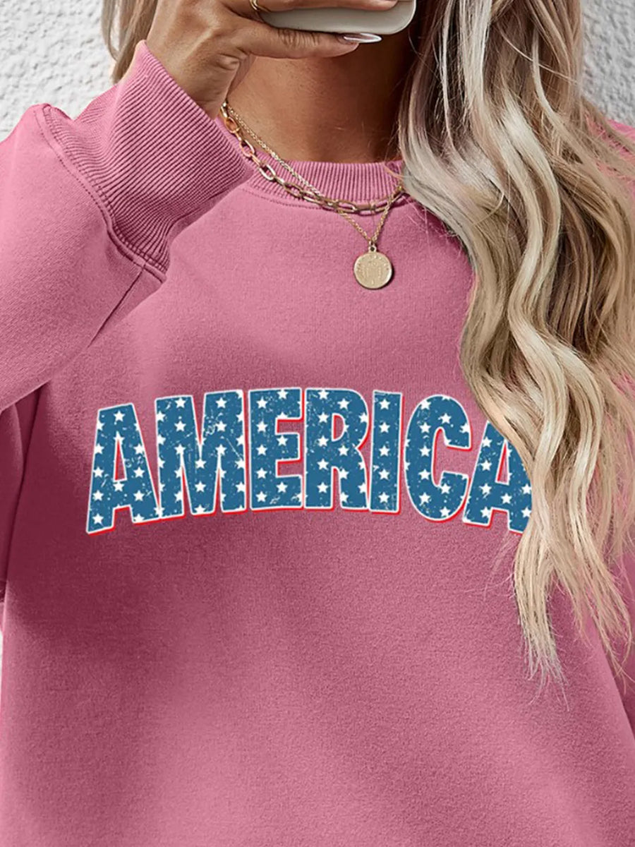 America graphic crewneck sweatshirt in blush pink with distressed stars and stripes lettering.