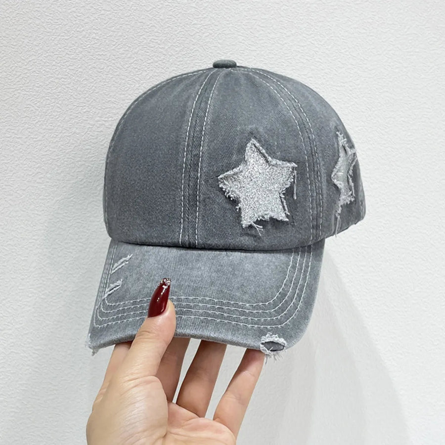 Gray distressed baseball cap with glitter star patches and frayed details.