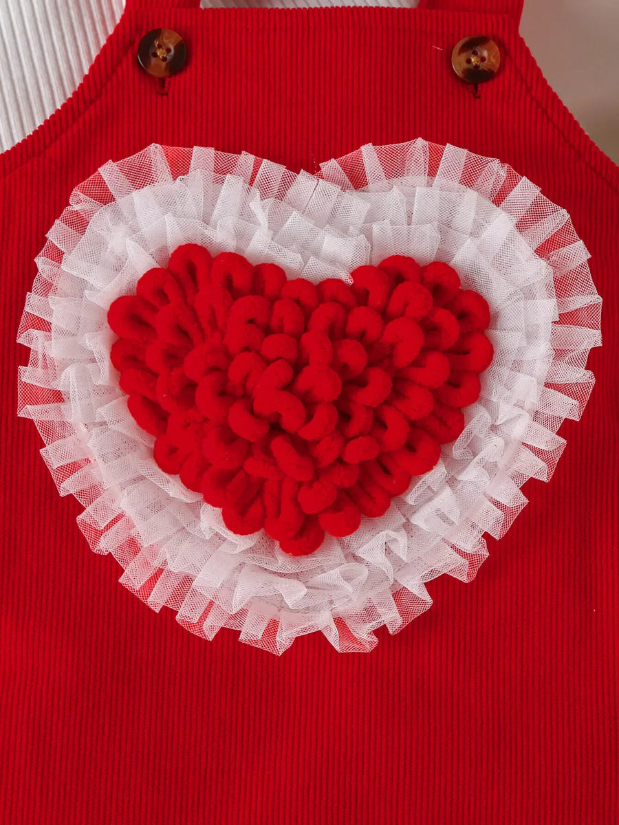 Red corduroy baby dress with white ruffled trim and a textured red heart applique.